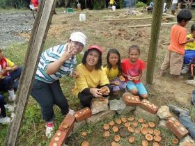 Volunteers help the students to make and fire their own clay pots