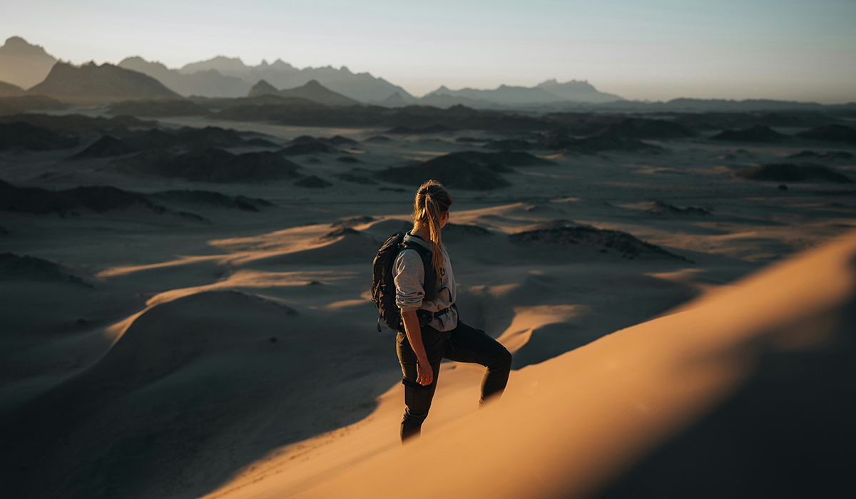 A woman looks out over a desert toward the horizon