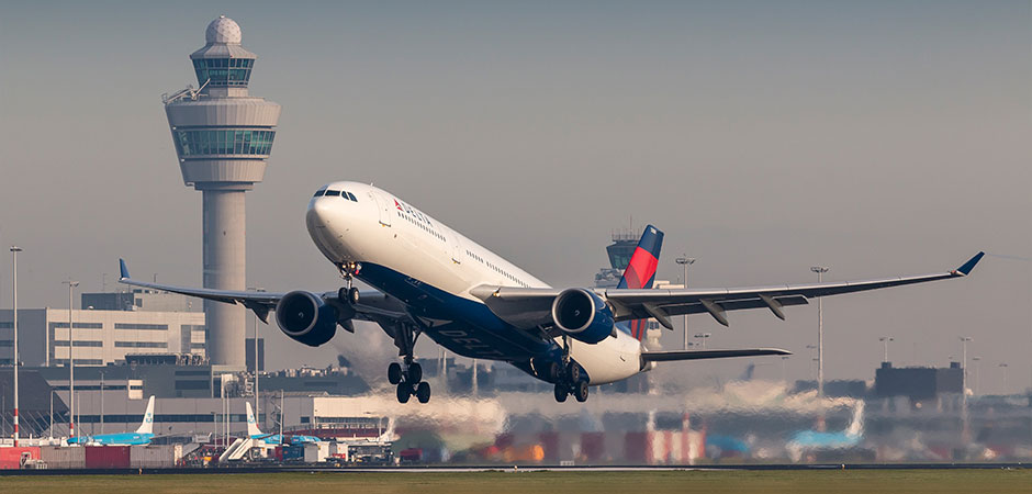 american plane taking off from amsterdam leaving trails of pollution