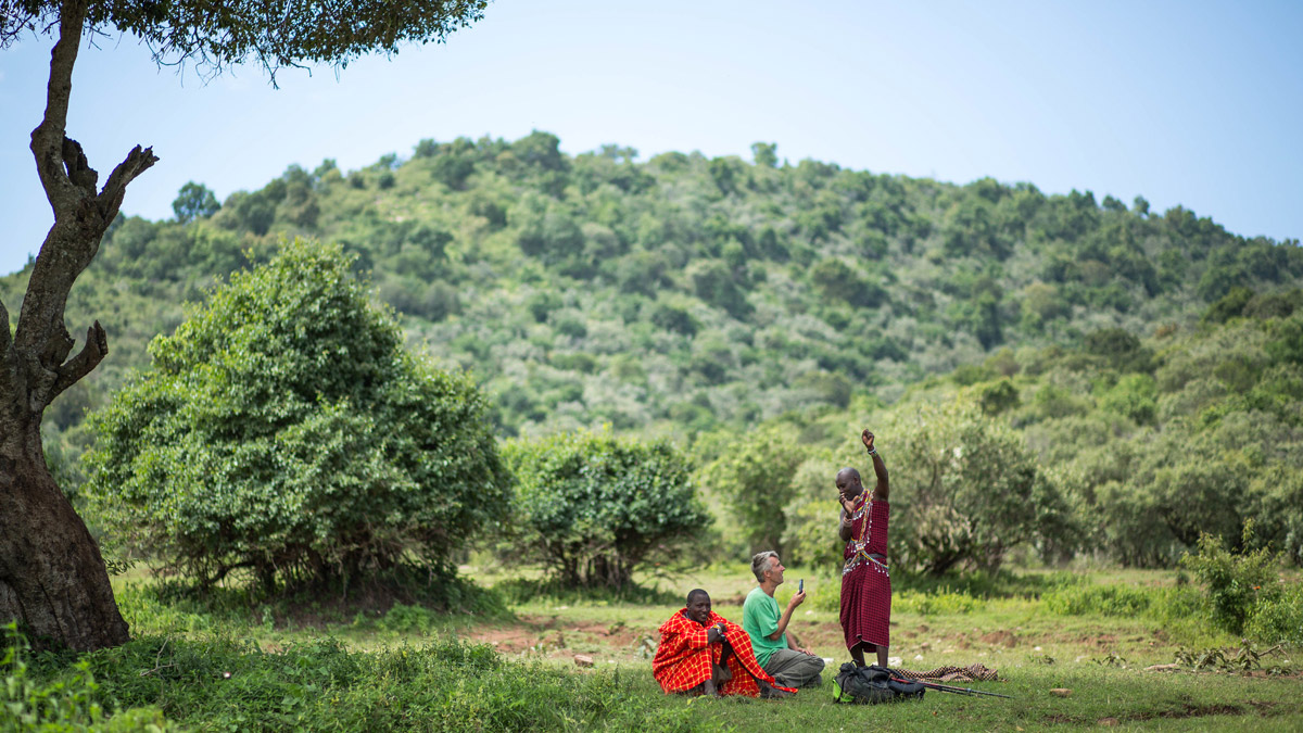 Masaai guide tells traveller a story out in the bush in Kenya