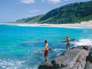 Surfers on rocks in Western Australia. Photo by Tourism Western Australia