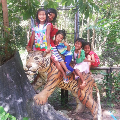 Children sitting on tiger statue
