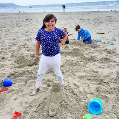 Girl on beach with buckets and spades