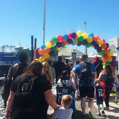 Families walking through an arc of balloons