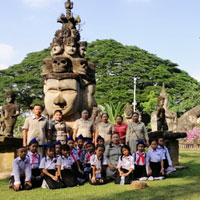 Children in front of buddha head statue