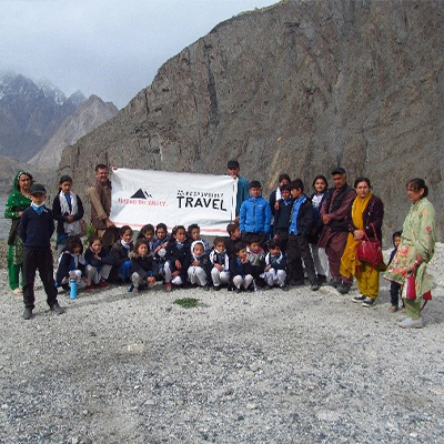 The kids pose with a banner with a beautiful landscape behind them