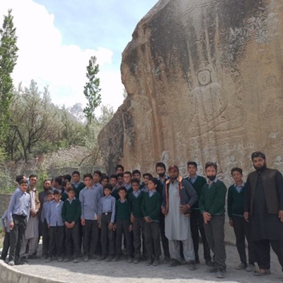 The kids pose under a giant cliff face