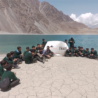 Group photo of everyone infront of the lake with a Responsible Travel banner