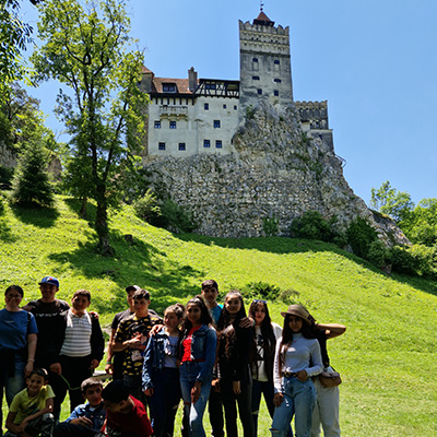 The children pose for a photo below Bran Castle